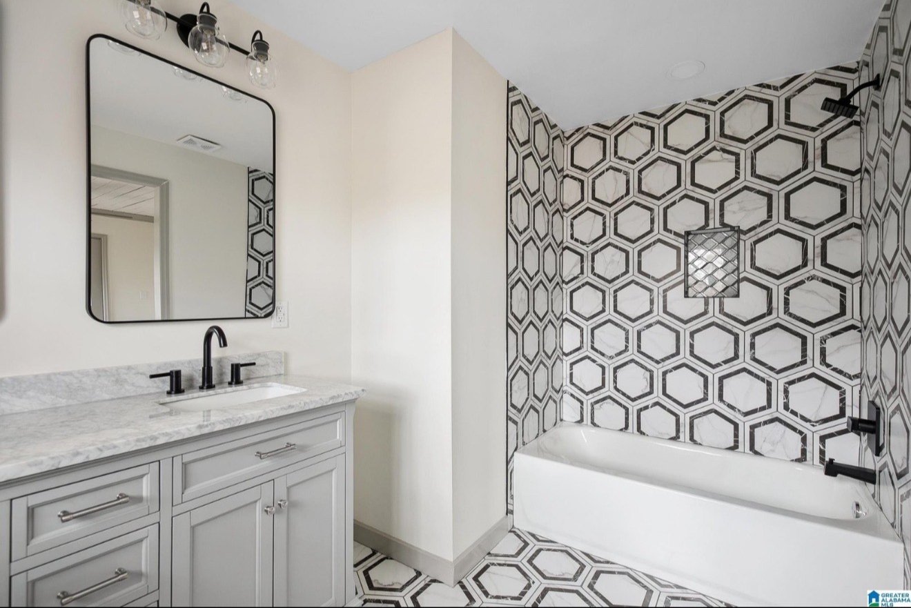 White bathroom with grey vanity and patterned hexagonal wall tile