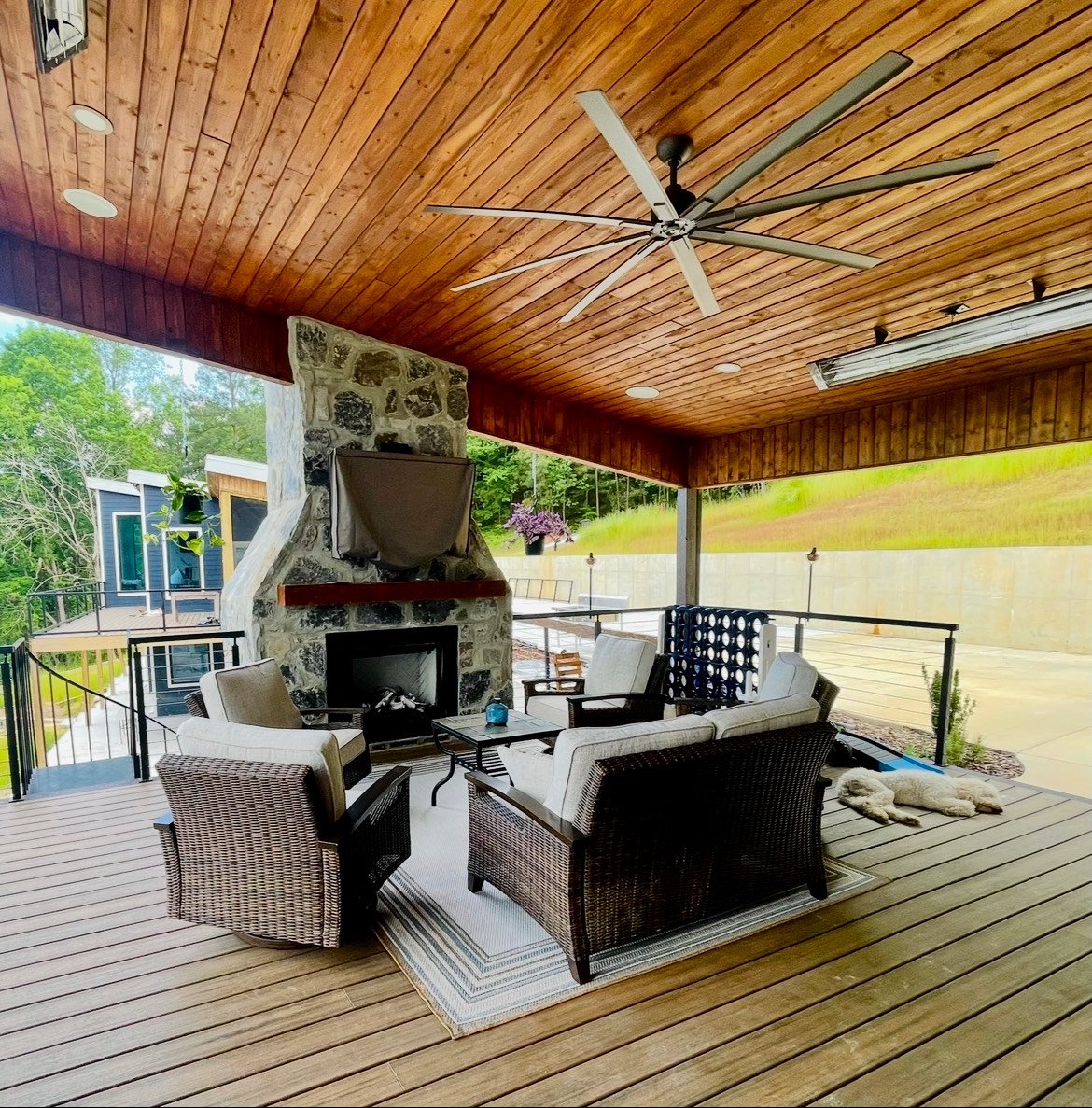 Covered porch with timber ceiling and outdoor stone fireplace