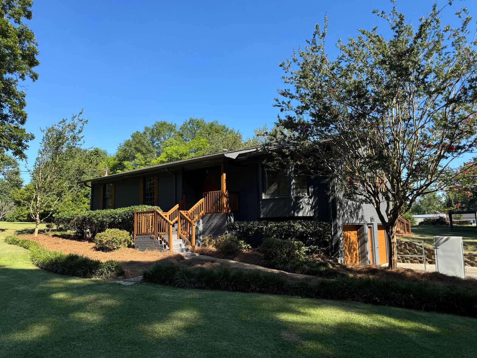 Dark exterior home surrounded by trees