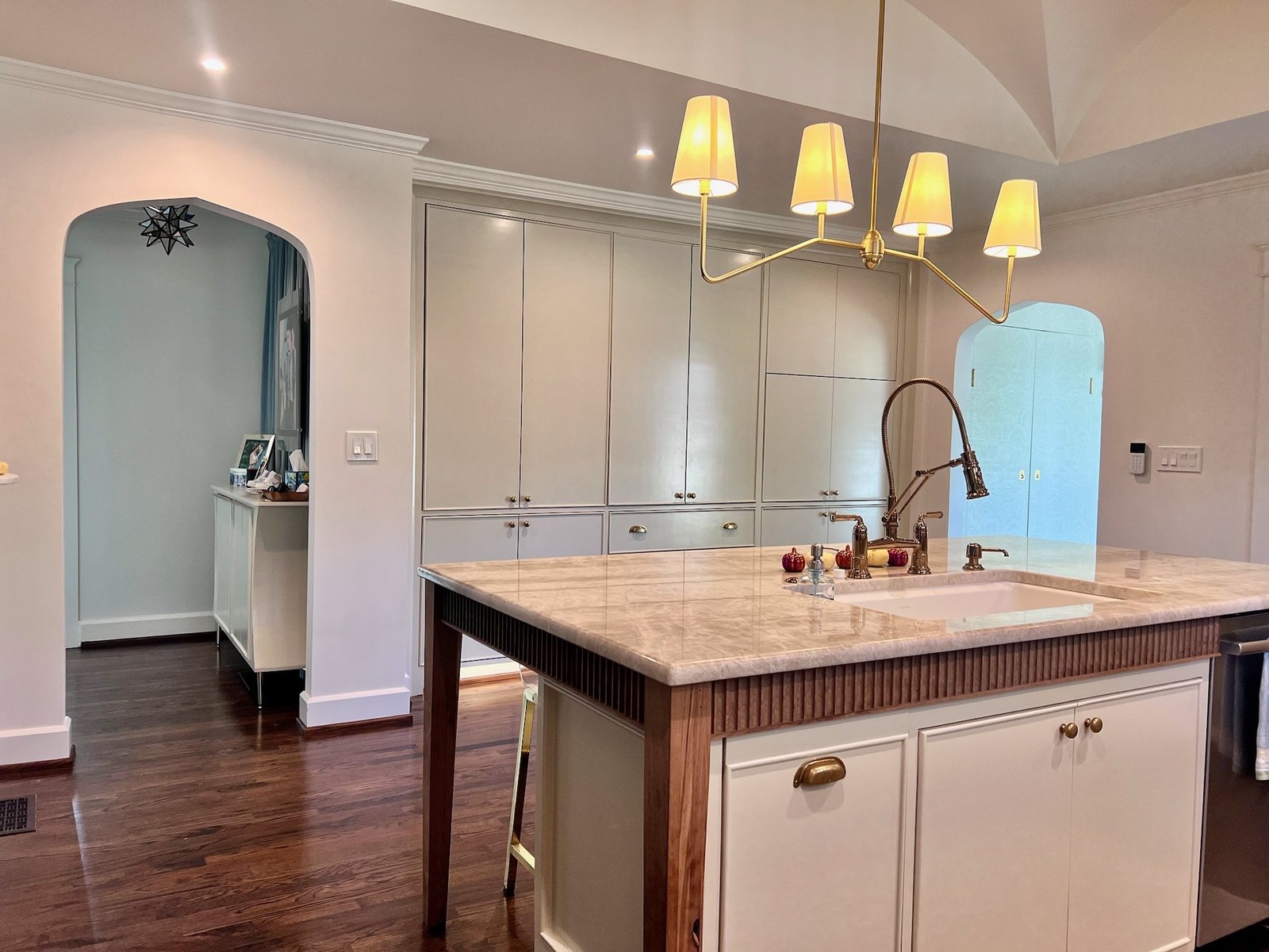 Kitchen island with pendant lighting and white cabinetry